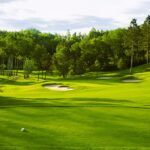 Golf green with bunkers in afternoon sunlight